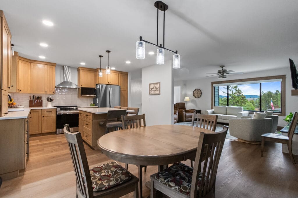 Custom kitchen remodel in Spearfish, SD by JG Carpentry with natural maple shaker cabinets, white quartz island and open layout to the living room.