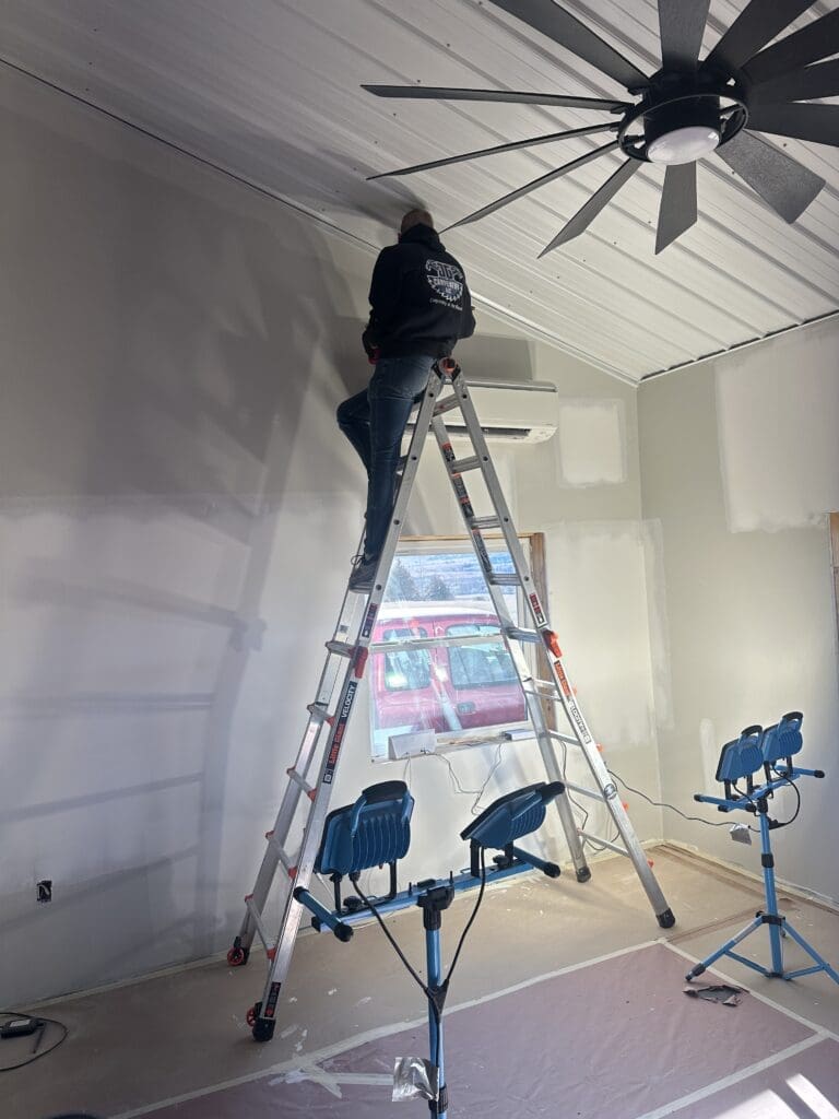 Carpenter on ladder for JG Carpentry painting for remodel project in Spearfish, SD.